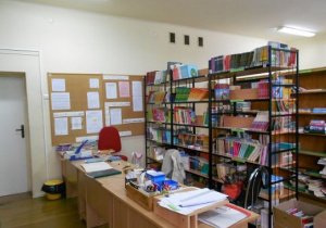 Wnętrze biblioteki z regałami wypełnionymi książkami.