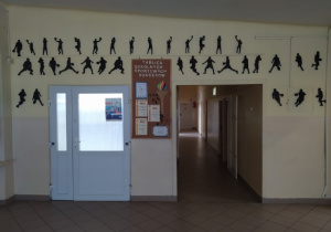 Ściana z czarnymi sylwetkami przedstawiającymi różne dyscypliny sportu.